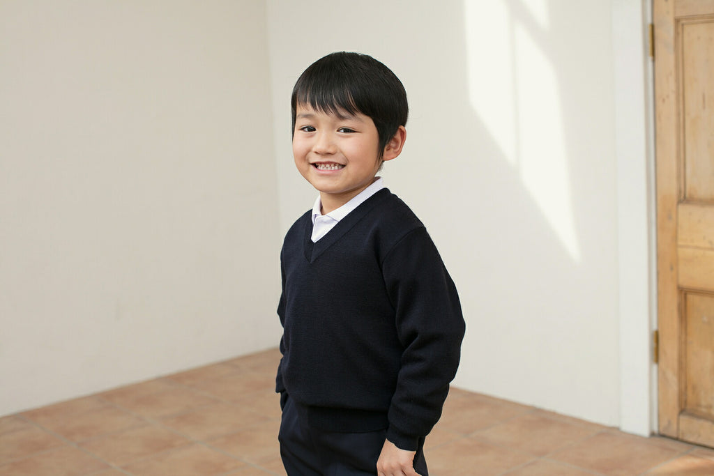キッズ スクールセーターを着た男の子
