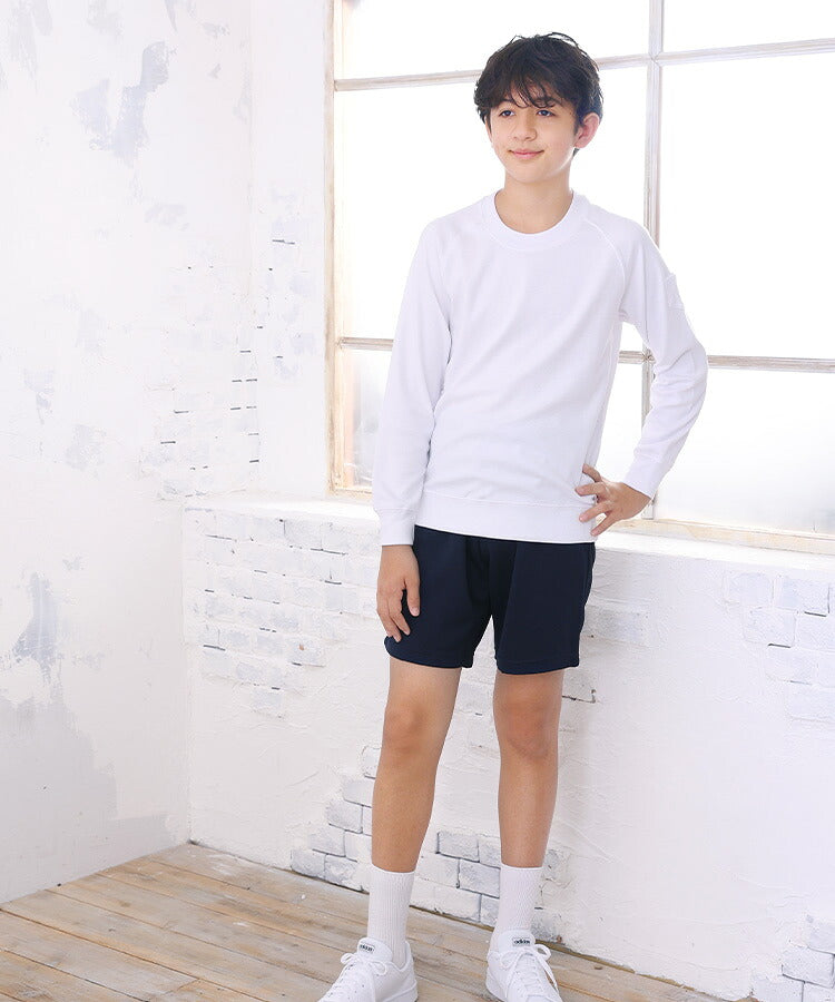 体操服 長袖を着て窓辺に立つ男の子の全身