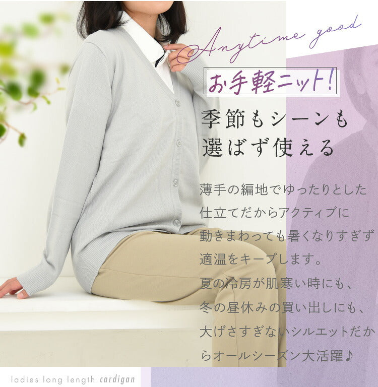 ライトグレーのカーディガンを着て座る女性